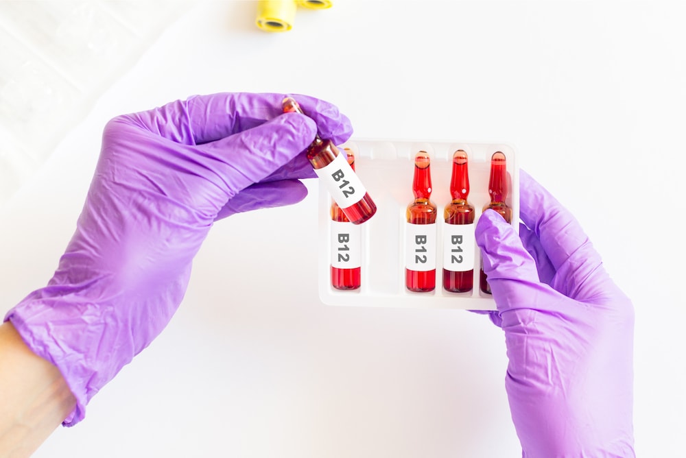 Doctor holding vials of B12 in a medical facility.
