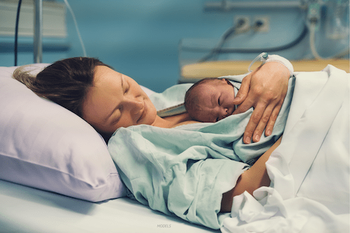 Woman holding her newborn baby in hospital.