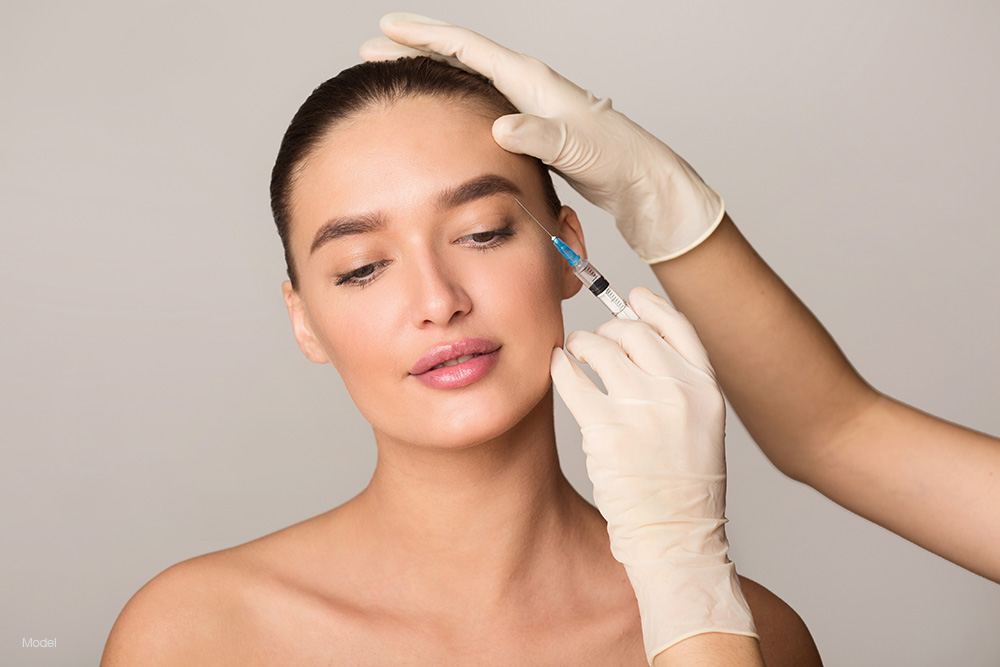 A young woman getting an injection in her crows feet area